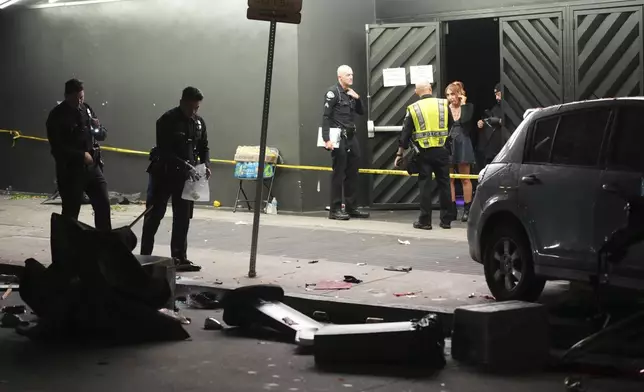 Law enforcement investigate the scene where a vehicle rammed into a crowd of people waiting to enter a nightclub along a busy boulevard in Los Angeles early Saturday, July 19, 2025 injuring several people. (AP Photo/Damian Dovarganes)