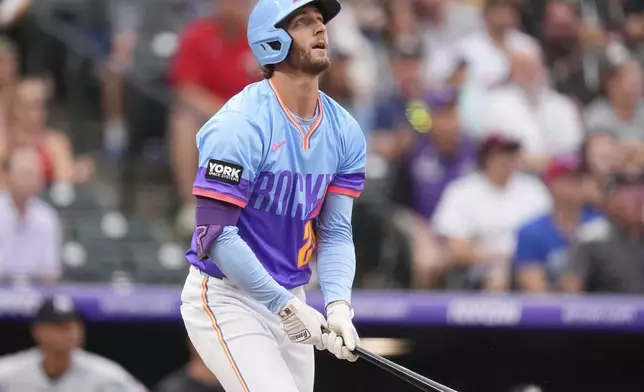 Colorado Rockies' Ryan McMahon follows the flight of his two-run home run off Minnesota Twins starting pitcher Chris Paddack in the first inning of a baseball game Friday, July 18, 2025, in Denver. (AP Photo/David Zalubowski)