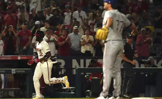 Los Angeles Angels' Jorge Soler, left, heads home after hitting a two-run home run as Texas Rangers relief pitcher Luke Jackson stretches on the mound during the eighth inning of a baseball game Wednesday, July 9, 2025 in Anaheim, Calif. (AP Photo/Mark J. Terrill)