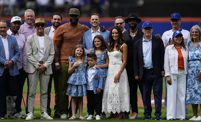 Former New York Mets third baseman David Wright, center, poses for a picture with his family and others during a ceremony ahead of a baseball game against the Cincinnati Reds, Saturday, July 19, 2025, in New York. (AP Photo/Yuki Iwamura)