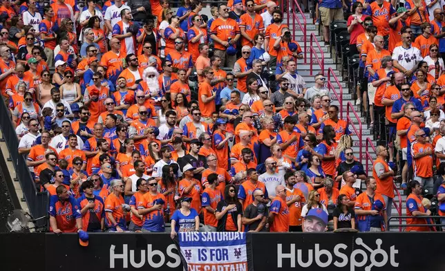 Peopls attend a ceremony for former New York Mets third baseman David Wright ahead of a baseball game against the Cincinnati Reds, Saturday, July 19, 2025, in New York. (AP Photo/Yuki Iwamura)