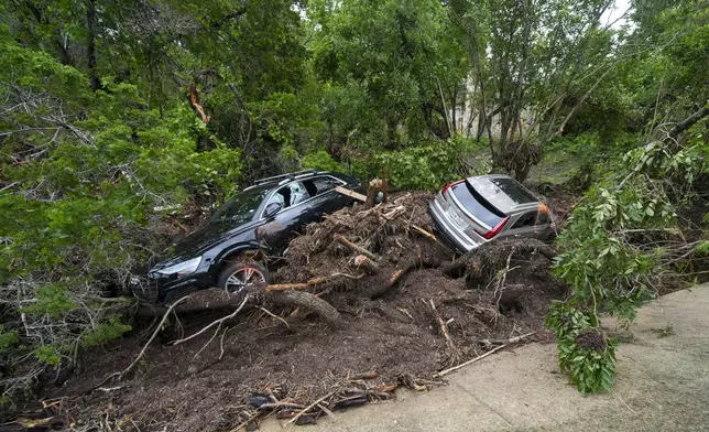 Vehicles are seen after they were washed away along the Guadalupe River after a flash flood swept through the area Saturday, July 5, 2025, in Hunt, Texas. (AP Photo/Julio Cortez)