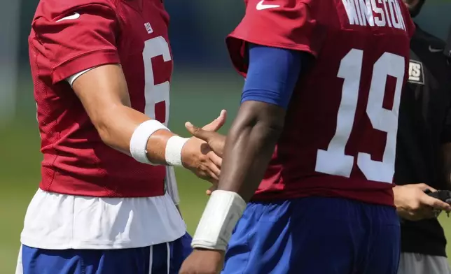 New York Giants quarterback Jaxson Dart, left, greets Jameis Winston during practice at the team’s NFL football training camp in East Rutherford, N.J., Wednesday, July 23, 2025. (AP Photo/Seth Wenig)