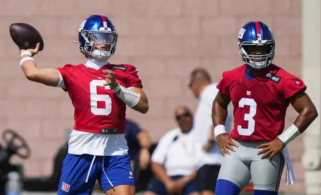 New York Giants quarterback Jaxson Dart (6) throws as quarterback Russell Wilson (3) watches during practice at the team's NFL football training camp in East Rutherford, N.J., Wednesday, July 23, 2025. (AP Photo/Yuki Iwamura)