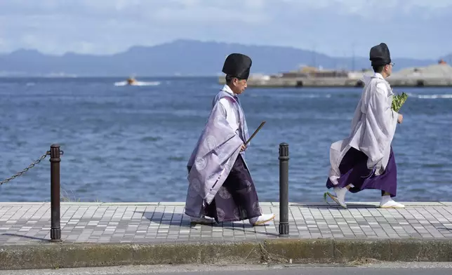 Shinto priests attend the annual Kurihama Sumiyoshi Shrine Festival at Kurihama, Yokosuka city, south of Tokyo Sunday, July 27, 2025. (AP Photo/Eugene Hoshiko)