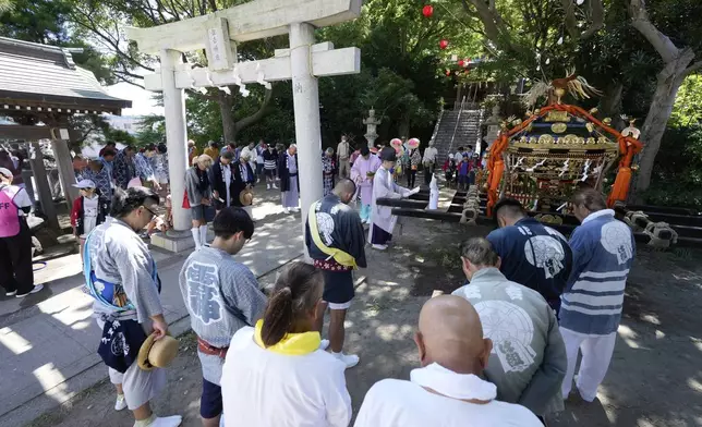 Participants attend a ritual at Sumiyoshi Shrine for a procession with a portable shrine called mikoshi at Kurihama, Yokosuka city, south of Tokyo Sunday, July 27, 2025. (AP Photo/Eugene Hoshiko)
