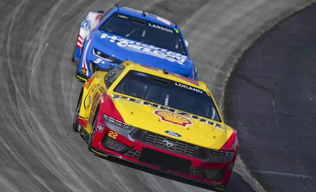 Joey Logano, front, drives ahead of Kyle Larson through Turn 2 during a NASCAR Cup Series auto race at Dover Motor Speedway, Sunday, July 20, 2025, in Dover, Del. (AP Photo/Derik Hamilton)