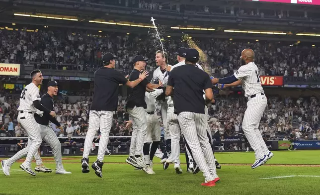 New York Yankees' Ryan McMahon celebrates with teammates after hitting a walk-off RBI single during the 11th inning of a baseball game against the Tampa Bay Rays Wednesday, July 30, 2025, in New York. (AP Photo/Frank Franklin II)