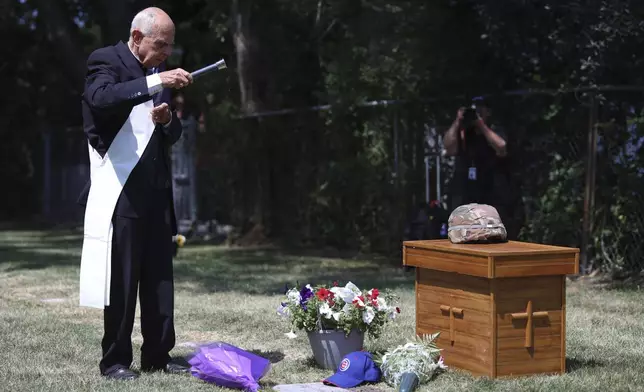 Deacon Glenn Tylutki, of Chicago Catholic Cemeteries, blesses the grave of 75-year-old Pfc. Reba C. Bailey, a former missing person cold case named Seven Doe, during a military funeral Tuesday, July 1, 2025, at Mount Olivet Catholic Cemetery in Chicago. (AP Photo/Talia Sprague)
