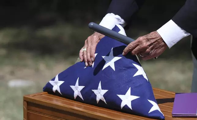 Deacon Glenn Tylutki, of Chicago Catholic Cemeteries, adjusts an American flag prior to a military funeral for 75-year-old Pfc. Reba C. Bailey, a former missing person cold case named Seven Doe, Tuesday, July 1, 2025, at Mount Olivet Catholic Cemetery in Chicago. (AP Photo/Talia Sprague)