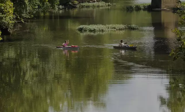 People kayak along the Stones River, Friday during a heat advisory, July 25, 2025, in Murfreesboro, Tenn. (AP Photo/George Walker IV)
