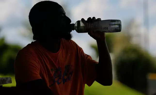 Marqui Scruggs takes a drink after playing basketball during a heat advisory Friday, July 25, 2025, in Murfreesboro, Tenn. (AP Photo/George Walker IV)