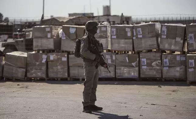 FILE - An Israeli soldier stands beside humanitarian aid packages awaiting pickup on the Palestinian side of the Kerem Shalom crossing in the Gaza Strip, Thursday, July 24, 2025, during a media tour organized by the Israeli army. (AP Photo/Ohad Zwigenberg, file)
