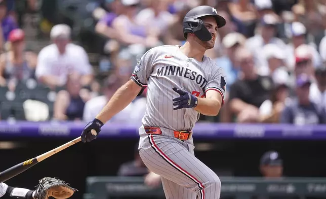 Minnesota Twins' Matt Wallner follows the flight of his two-run home run off Colorado Rockies starting pitcher Germán Márquez in the third inning of a baseball game Sunday, July 20, 2025, in Denver. (AP Photo/David Zalubowski)