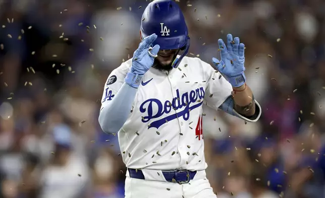 Los Angeles Dodgers outfielder Andy Pages is showered with sunflower seeds after hitting a home run during the fourth inning of a baseball game against the Minnesota Twins Tuesday, July 22, 2025, in Los Angeles. (AP Photo/Eric Thayer)