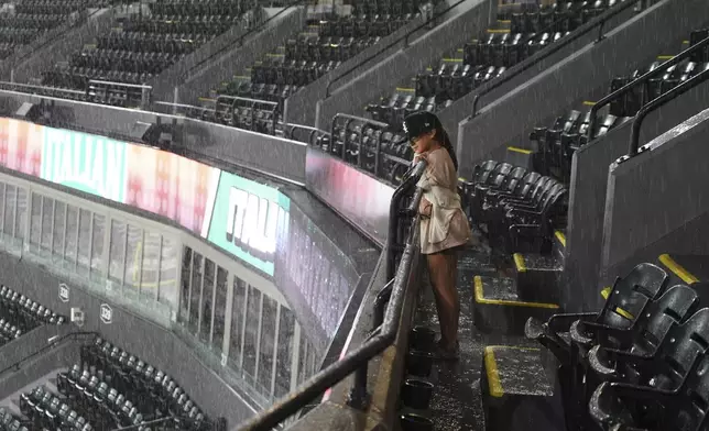 A young fan looks down at the field during a rain delay in the seventh inning of a baseball game between the Toronto Blue Jays and the Chicago White Sox in Chicago, Tuesday, July 8, 2025. (AP Photo/Nam Y. Huh)