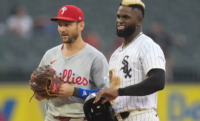 Philadelphia Phillies shortstop Trea Turner (7), left, stands next to White Sox's Luis Robert Jr. (88) as a tag-out play is reviewed during the sixth inning of a baseball game Wednesday, July 30, 2025, in Chicago. (AP Photo/Erin Hooley)