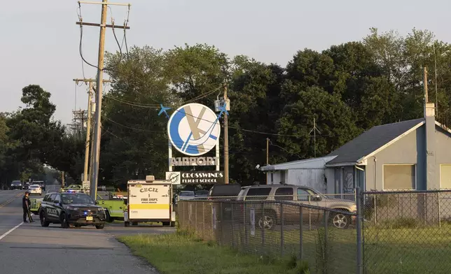 First responders work the scene at Cross Keys Airport in Gloucester County, N.J., after a skydiving aircraft went off the end of a runway and crashed into the woods Wednesday, July 2, 2025. (Kaiden J. Yu/The Philadelphia Inquirer via AP)