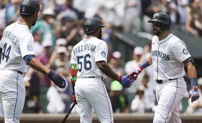 Seattle Mariners designated hitter Cal Raleigh, right, celebrates with Randy Arozarena, center, and Julio Rodriguez, left, after hitting a two-run home run during the first inning of a baseball game against the Pittsburgh Pirates, Friday, July 4, 2025, in Seattle. (AP Photo/Ryan Sun)