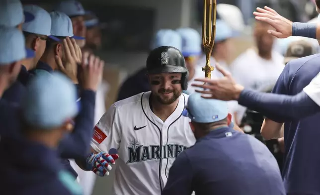 Seattle Mariners designated hitter Cal Raleigh celebrates in the dugout after hitting a solo home run during the sixth inning of a baseball game against the Pittsburgh Pirates, Friday, July 4, 2025, in Seattle. (AP Photo/Ryan Sun)