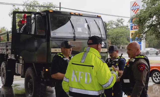 Members the Kerrville Fire Department and Texas Department of Public Safety refuel trucks after deadly flooding in Kerrville, Texas, Friday July 4, 2025. (Christopher Lee/The San Antonio Express-News via AP)