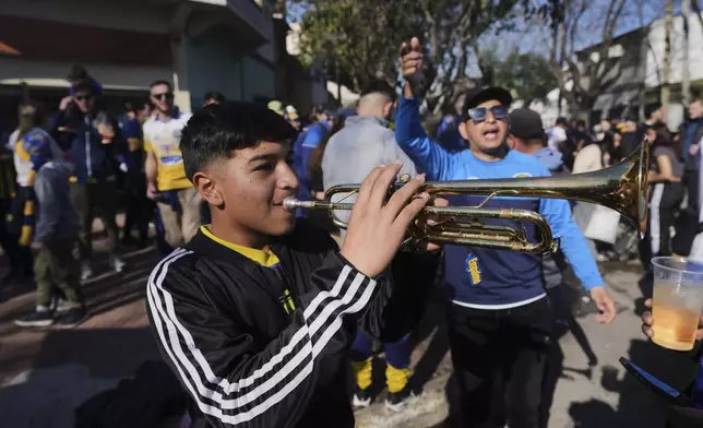 Rosario Central soccer fans get revved up as they arrive for a soccer match in Buenos Aires, Saturday, July 19, 2025, after the soccer federation lifted a 12-year ban as a test run on away fans in Argentina’s local leagues. (AP Photo/Gustavo Garello)