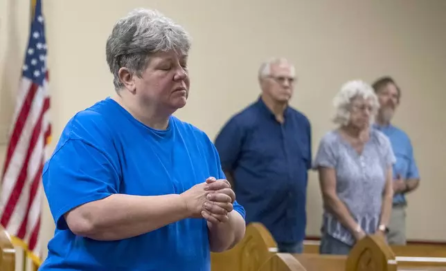 Kelly Barker prays during services at the Hunt Baptist Church on Sunday, July 6, 2025, in Hunt, Texas. The small town of Hunt sits on the bank of the Guadalupe River and was severely damaged by recent flooding. (AP Photo/Rodolfo Gonzalez)