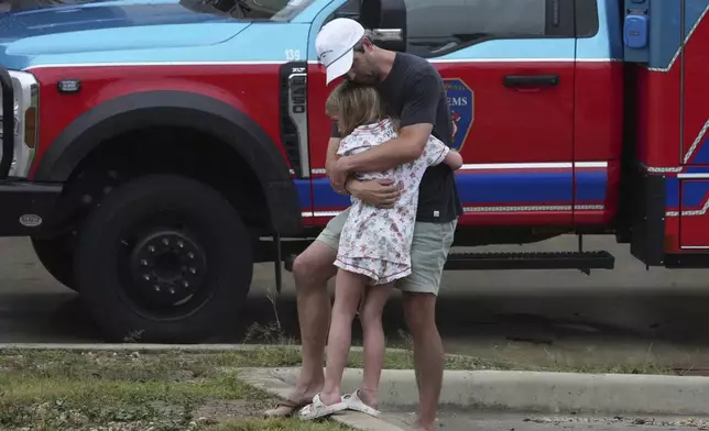 People are reunited at a reunification center after flash flooding hit the area, Friday, July 4, 2025, in Ingram, Texas. (AP Photo/Eric Gay)