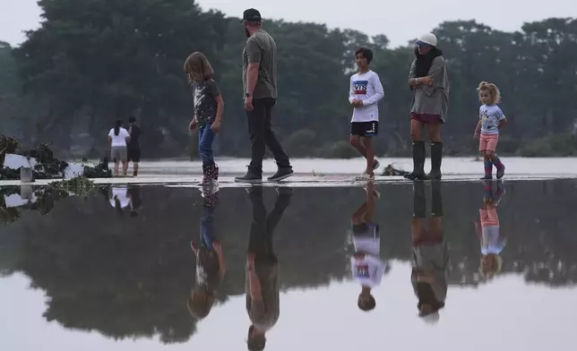 Onlookers survey damage along the Guadalupe River after a flash flood swept through the area, Friday, July 4, 2025, in Kerrville, Texas. (AP Photo/Eric Gay)