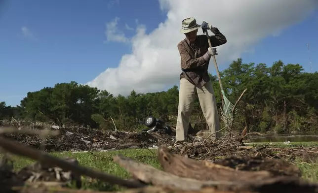 Charles Hanson, 91, cleans up flood debris, Tuesday, July 8, 2025, at Guadelupe Park in Kerrville, Texas. (AP Photo/Joshua A. Bickel)