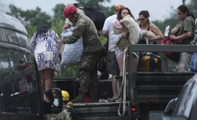 First responders deliver people to a reunification center after flash flooding in the area, Friday, July 4, 2025, in Ingram, Texas. (AP Photo/Eric Gay)