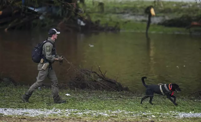 Officials comb through the banks of the Guadalupe River after a flash flood swept through the area Saturday, July 5, 2025, in Hunt, Texas. (AP Photo/Julio Cortez)