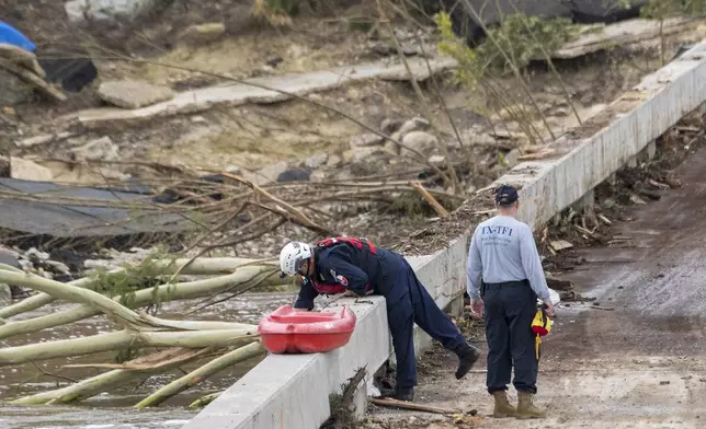 Members of the Texas A&amp;M Task Force 1 Search &amp; Rescue inspect the Cade Loop bridge along the Guadalupe River on Saturday, July 5, 2025, in Ingram, Texas. (AP Photo/Rodolfo Gonzalez)