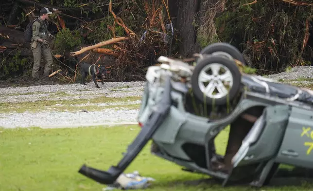 Officials comb through the banks of the Guadalupe River after a flash flood swept through the area Saturday, July 5, 2025, in Hunt, Texas. (AP Photo/Julio Cortez)