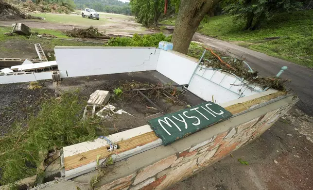A Camp Mystic sign is seen near the entrance to the establishment along the banks of the Guadalupe River after a flash flood swept through the area in Hunt, Texas, Saturday, July 5, 2025. (AP Photo/Julio Cortez)