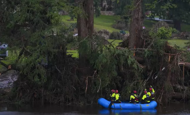 Rescue workers are seen a boat as they search for missing people near Camp Mystic along the Guadalupe River after a flash flood swept through the area Sunday, July 6, 2025, in Hunt, Texas. (AP Photo/Julio Cortez)