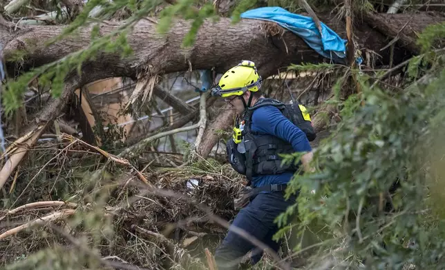 First responders from College Station Fire Department search along the banks of the Guadalupe River, as rescue efforts continue following extreme flooding, Sunday, July 6, 2025, in Ingram, Texas. (AP Photo/Rodolfo Gonzalez)