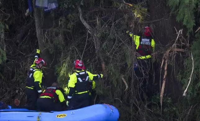Officials assist with a recovery effort at Camp Mystic along the Guadalupe River after a flash flood swept through the area Sunday, July 6, 2025, in Hunt, Texas. (AP Photo/Julio Cortez)