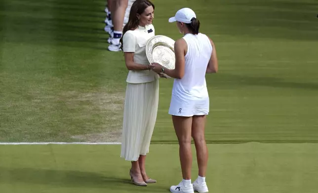 Britain's Kate, Princess of Wales presents the Venus Rosewater Dish to Iga Swiatek, following her victory over Amanda Anisimova in the Ladies' Singles Final at the Wimbledon Tennis Championships in London, Saturday, July 12, 2025. (Ben Whitley/PA via AP)