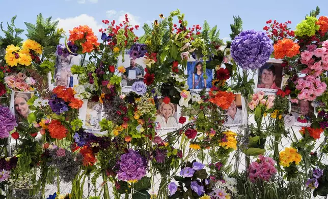 Photographs of flood victims are displayed on a memorial wall in Kerrville, Texas, Thursday, July 10, 2025. (AP Photo/Ashley Landis)