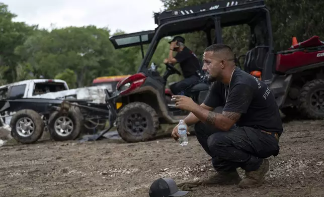 West Odessa Volunteer Firefighter Jed Wolske takes a smoke break while aiding in search and rescue efforts along the Guadalupe River, days after a flash flood swept through the area, Monday, July 7, 2025, in Ingram, Texas. (AP Photo/Eli Hartman)