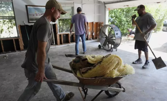 Volunteers help clean up a house after flooding in Kerrville, Texas on Tuesday, July 8, 2025. (AP Photo/Ashley Landis)