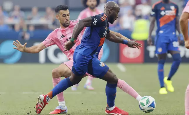 Inter Miami's Sergio Busquets, left, tries to stop the ball against FC Cincinnati's Tah Brian Anunga during the first half of an MLS soccer match, Wednesday, July 16, 2025, in Cincinnati. (AP Photo/Jay LaPrete)