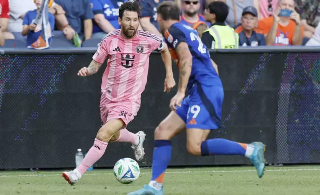 Inter Miami's Lionel Messi, left, dribbles the ball as FC Cincinnati's Lukas Engel defends during the first half of an MLS soccer match, Wednesday, July 16, 2025, in Cincinnati. (AP Photo/Jay LaPrete)