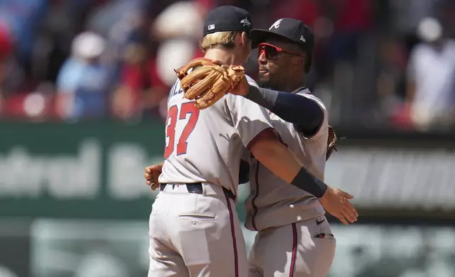 Atlanta Braves' Ozzie Albies and Luke Williams (37) celebrate a victory over the St. Louis Cardinals following a baseball game Saturday, July 12, 2025, in St. Louis. (AP Photo/Jeff Roberson)