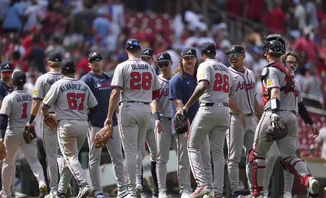 Members of the Atlanta Braves celebrate a victory over the St. Louis Cardinals following a baseball game Saturday, July 12, 2025, in St. Louis. (AP Photo/Jeff Roberson)