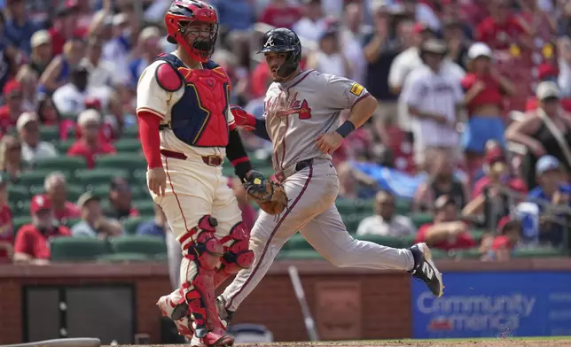Atlanta Braves' Nacho Alvarez Jr., right, scores past St. Louis Cardinals catcher Yohel Pozo during the ninth inning of a baseball game Saturday, July 12, 2025, in St. Louis. (AP Photo/Jeff Roberson)