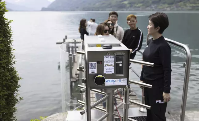 Korean visitors get on the pier at Lake Brienz after paying 5 Swiss Francs in Iseltwald, Switzerland, Sunday, May 21, 2023. (Peter Klaunzer/Keystone via AP)