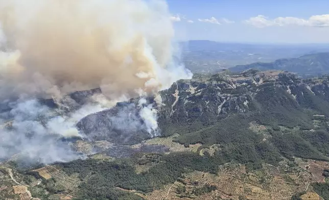 In this photo released by Agents Rurals de Catalunya, uncontrolled fire rages across the forrest in Pauls, in the rural province of Tarragona , Spain, Tuesday, July 8, 2025. (Agents Rurals de Catalunya via AP)