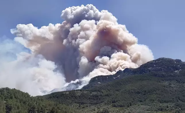 In this photo released by Agents Rurals de Catalunya, uncontrolled fire rages across the forrest in Pauls, in the rural province of Tarragona , Spain, Tuesday, July 8, 2025. (Agents Rurals de Catalunya via AP)
